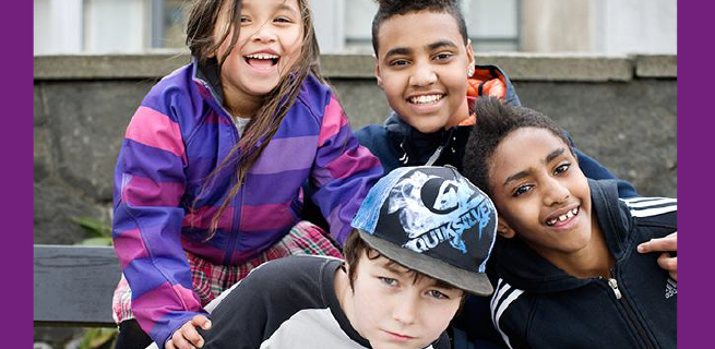 Fyra barn som ler och tittar mot kameran