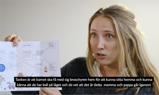 Bild på en blond kvinna som visar något på en broschyr