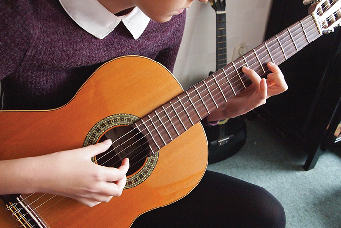 En person som spelar på en gitarr 