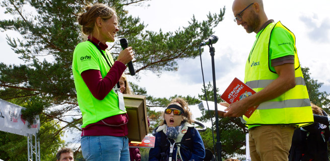 Bild på Anna, hennes dotter och en man som står på scen