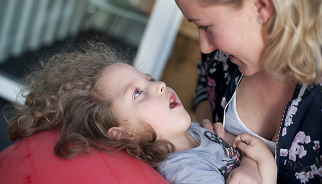 Mamma Annie hjälper Elvira att studsa på sin pilatesboll.
