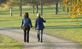 Två personer promenerar i en park