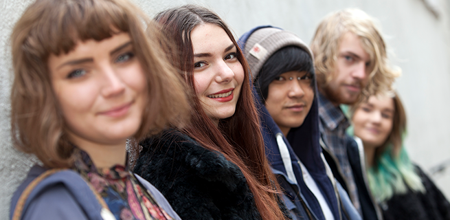 Ungdomar står letade mot en vägg