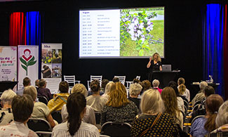 Maria Ahlqvist står på scenen framför publiken.