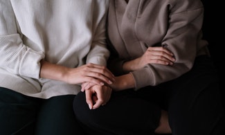 Två personer håller varandra i händerna.