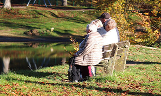 Foto Pixabay personer sitter på en parkbänk vid en sjö